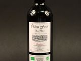 a bottle of red wine sitting on top of a black table