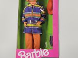 La poupée Barbie se trouve dans une boîte sur laquelle est posé un chapeau.
