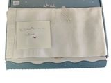 une boîte ouverte contenant une serviette blanche et un mot posé dessus