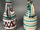 two vases with designs on them sitting next to each other