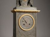 une horloge posée sur un support sur lequel se trouve une autre horloge