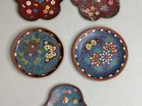 quatre petites assiettes ornées de fleurs et de papillons, accrochées au mur