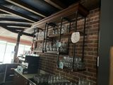 de nombreux verres sur les étagères au-dessus du bar