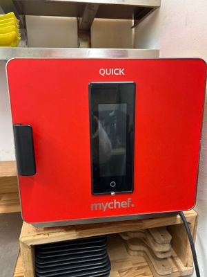 the microwave oven is red and has a digital screen on top of it