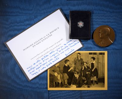 une vieille photo montrant un groupe de personnes assises sur une couverture bleue