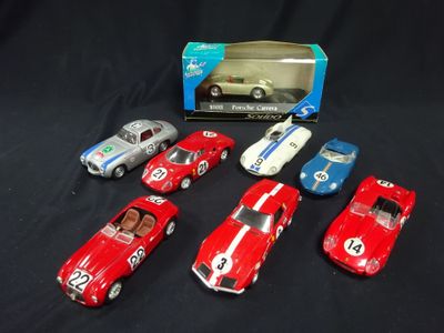 six toy cars in a box on a black surface