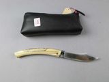 a knife that is laying next to a pouch