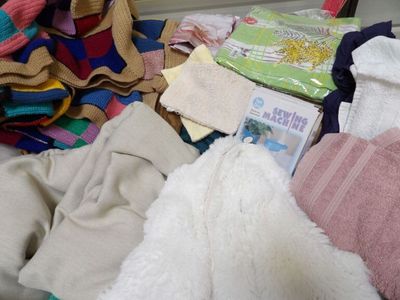 a pile of clothes and towels on a bed