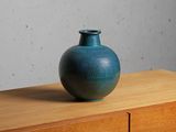 a blue vase sitting on top of a wooden dresser