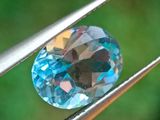 un gros plan d'un diamant bleu tenu par une pince