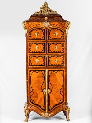 une vieille commode en bois comportant de nombreux tiroirs et ornée de sculptures
