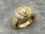 an image of a gold ring with diamonds on a gray surface