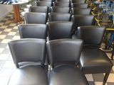 des rangées de chaises noires dans une pièce au sol en damier