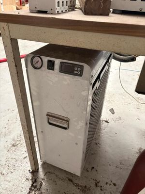 un petit réfrigérateur posé sous une table dans une pièce