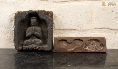 une petite statue de Bouddha assis dans un bloc de pierre