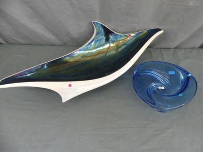 un dauphin en verre posé à côté d'un bol bleu