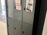three lockers in the hallway of a building with a sign on the door