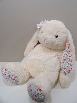 une peluche blanche avec un nœud sur la tête
