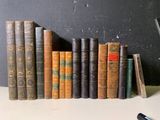 de nombreux livres anciens alignés sur une étagère à côté d'un téléphone portable