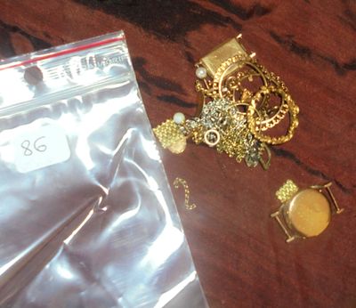 un sac contenant des bijoux posé sur une table, à côté d'une paire de ciseaux