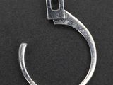 a close up of a silver ring with a small diamond on it