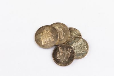 some coins are sitting on a white surface with a white background