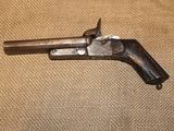 un gros plan d'un pistolet posé sur une table, avec un fond en tissu