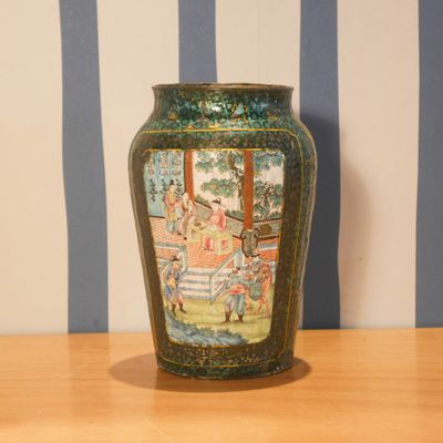 un vase avec un tableau posé sur une table