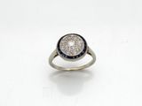 gros plan d'une bague en diamant et saphir sur une surface blanche