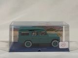 a green toy car in a clear box on a white surface