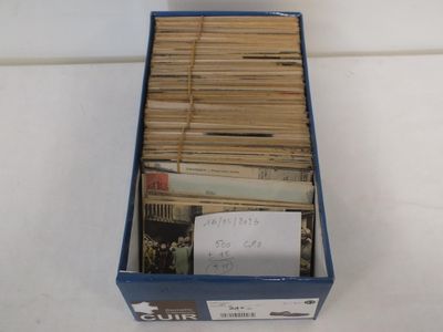 une boîte remplie de vieux livres posée sur une table blanche