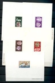 quatre timbres différents posés sur une feuille de papier posée sur une table