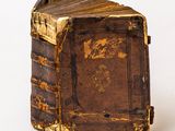 an old book that is sitting on a white surface