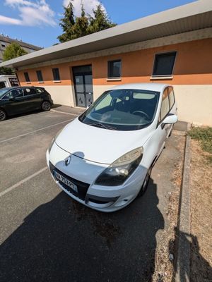 a picture of a white car parked in front of a building