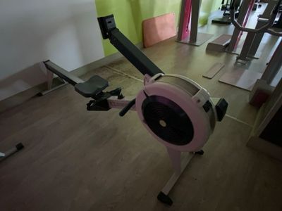 un rameur rose et noir dans une salle de sport