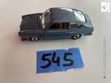 une petite voiture miniature posée sur une feuille de papier