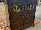 une commode ancienne dans une pièce où se trouve un tapis au sol