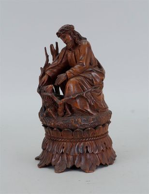 une vieille statue en bois représentant un homme assis sur une souche d'arbre