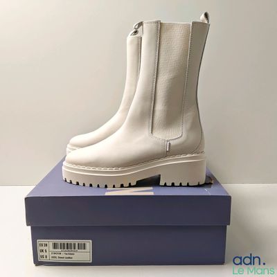 the white boots are sitting on top of a blue box
