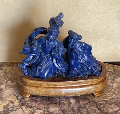 une figurine bleue posée sur un socle en bois, sur une table