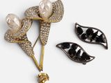 two black and white brooches with pearls on them