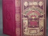 an old book with a red cover sitting on top of a table