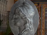 a silver medallion with a woman ' s face on it