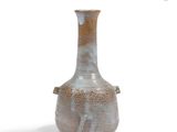 a small vase that is sitting on a white surface