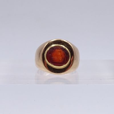 gros plan d'une bague en or avec une pierre rouge au centre