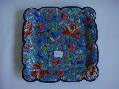 a blue plate with red and green flowers on it
