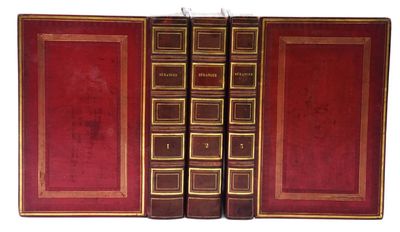 un vieux livre ouvert, dévoilant une couverture rouge aux bordures dorées