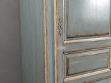 une photo d'une armoire bleue surmontée d'un miroir