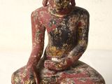 an image of a statue of a person sitting on top of a tree stump