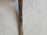 une cuillère sur laquelle se trouve une autre cuillère, posée sur une table